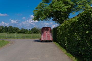 Fototapeta premium The horse trailer is parked under a tree