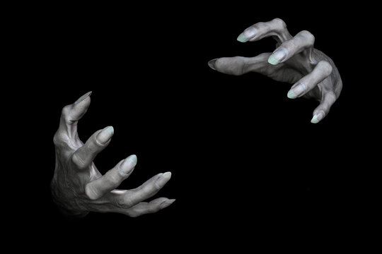 Creepy male hands of vampire or monster with sharp nails, isolated on black. Demons fingers grabbing something, low key, selected focus.