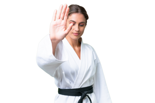 Young Uruguayan woman doing karate over isolated background making stop gesture and disappointed