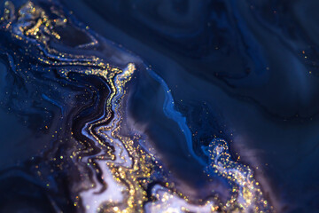 Colorful liquid paint abstract background. Blue and white acrylic paints with shining golden glitter