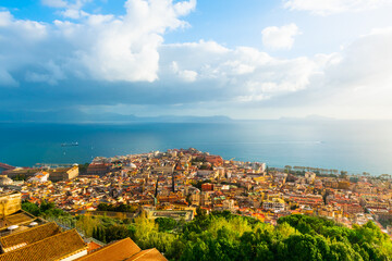 Panoramic view of Naples city and Gulf of Naples, Italy. Blue sea and the sky with clouds at sunset.