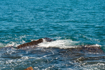Obraz premium Sea waves on the rocky beach. Ocean shore on a sunny day. 