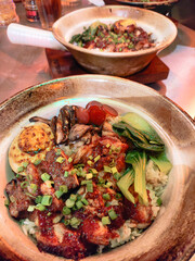 Delicious Asian Rice Bowl Claypot Topped with Pork Lapciong, Chicken and Greens