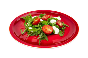 arugula with tomatoes and mozzarella on a red plate isolated on white