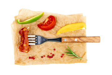 Chorizo salami on a fork surrounded by chopped vegetables top view isolated on white