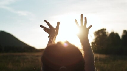 Little girl raising hands over warm sunset, enjoying life and nature. Child on summer field enjoying sunlight. Silhouette of preteen kid in sunlight rays. Air, environment concept. Dream of flying