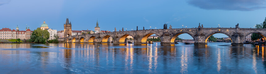 Fototapeta premium Charles Bridge (Karlův most) over Vltava river, illuminated in the evening, Prague, Czech Republic