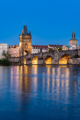 Fototapeta premium Charles Bridge (Karlův most) over Vltava river, illuminated in the evening, Prague, Czech Republic