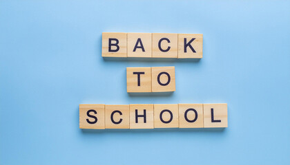 Text BACK TO SCHOOL on wooden blocks, blue background. Education concept. Flat lay, top view