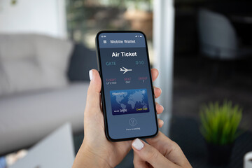 woman hands hold phone with air ticket application on screen