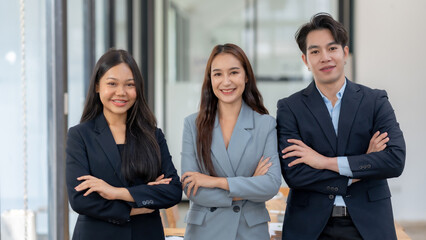 Professional business team posing with confidence in office environment, suited up and smiling, ready for success and teamwork.