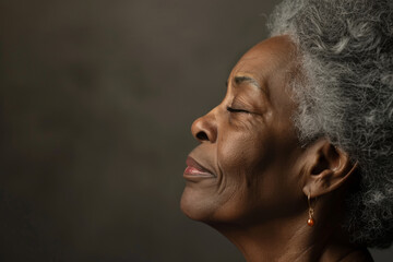 Obraz premium A close up of a black woman's face with her eyes closed looking to a side