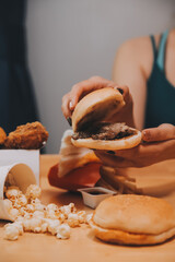 fast food, people and unhealthy eating concept - close up of woman hands holding hamburger or...