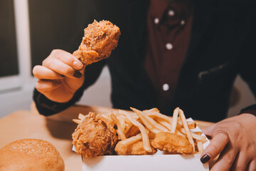 close up focus woman hand hold fried chicken for eat,girl with fast food concept