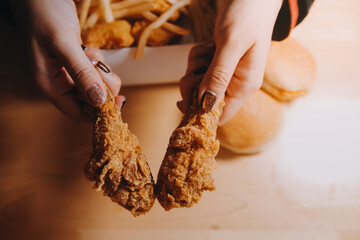 close up focus woman hand hold fried chicken for eat,girl with fast food concept