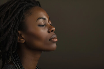 A close up of a black woman's face with her eyes closed looking to a side