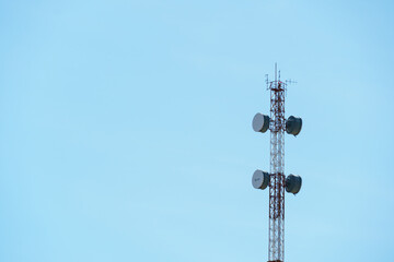 New GSM antennas on a high tower against a blue sky background. 5G signal transmissions are...