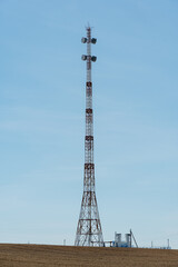 New GSM antennas on a high tower against a blue sky background. 5G signal transmissions are dangerous to health. Radiation pollution of the environment through cell towers. Harm to health