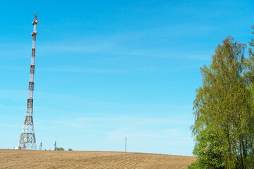 New GSM antennas on a high tower against a blue sky background. 5G signal transmissions are...