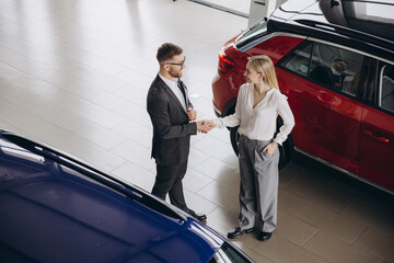 Car Sales Manager Showing Auto To Caucasian Lady Handshake Buyer Standing In Luxury Automobile...