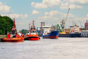 Fototapeta premium Port of Gdansk, Poland, Baltic Sea, port tugs on the left, Bunkering Tanker ANGON is sailing