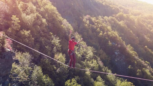 Brave Young Man Balancing On Rope Above Mountains Tree Nature Adventure