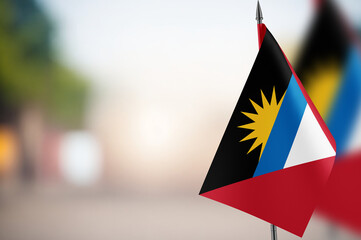 Small flags of Antigua and Barbuda on a blurred background