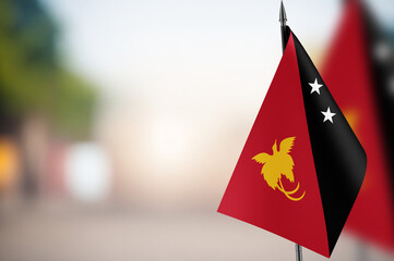 Small flags of Papua New Guinea on a blurred background