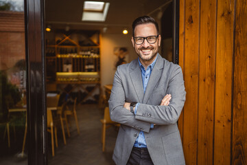 Portrait of adult man sommelier stand in front of winery and smile