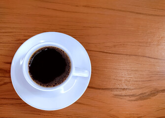 Cup of coffee on the wooden background
