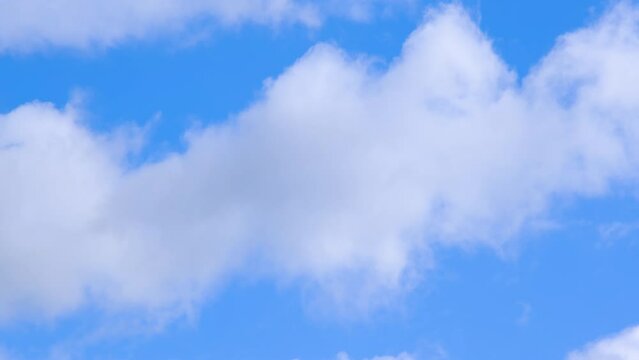 Beautiful serine blue sky with fluffy white clouds. 4K resolution video of sky and clouds