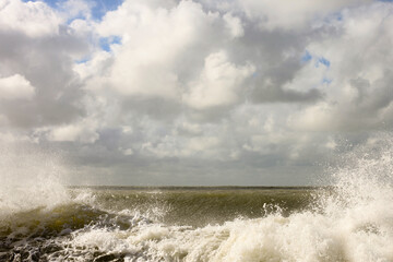 Nature background. Clouds over ocean waves on bright summer day.