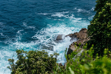 Ocean wave in slow motion crashing in sea background cinematic. Waves against volcanic rocks along the seashore of Cabo de Palos in Spain.