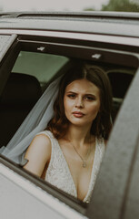 Portrait of a bride in a car in rainy weather.