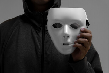 白い仮面を持つ男性