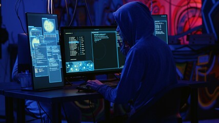 Hackers in dark room running code to breach defenses and exploit weaknesses in computer systems. Evil developers in basement getting past companies security networks, handheld camera shot © DC Studio