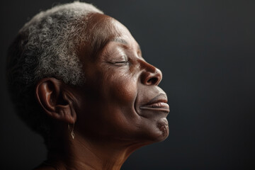 Obraz premium A close up of a black woman's face with her eyes closed looking to a side