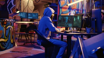 African american hacker doing computer sabotage using encryption trojan ransomware in hidden base....