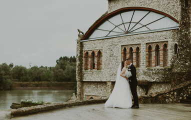 Portrait of a kissing bride and groom against the backdrop of a castle.