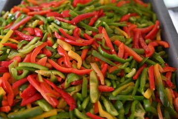 pimientos de tres colores, rojo, verde y amarillo en rajas