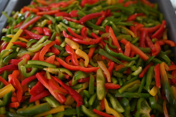 pimientos de tres colores, rojo, verde y amarillo en rajas