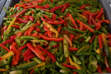 pimientos de tres colores, rojo, verde y amarillo en rajas