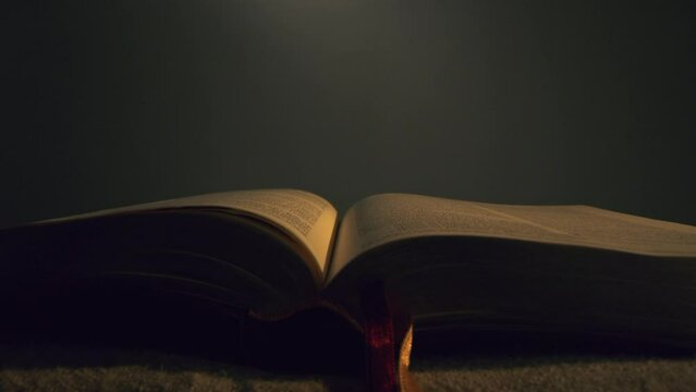 Bible Illuminated By A Candle Studio Shot Christian Faith Prayer slow motion 8K