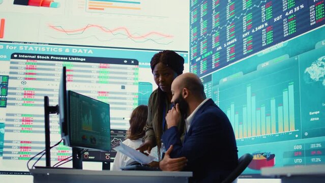 Diverse business analysts working together to evaluate costs and create a projection to deduct the future enterprise situation. Financial advisers specialists studying budget numbers. Camera B.