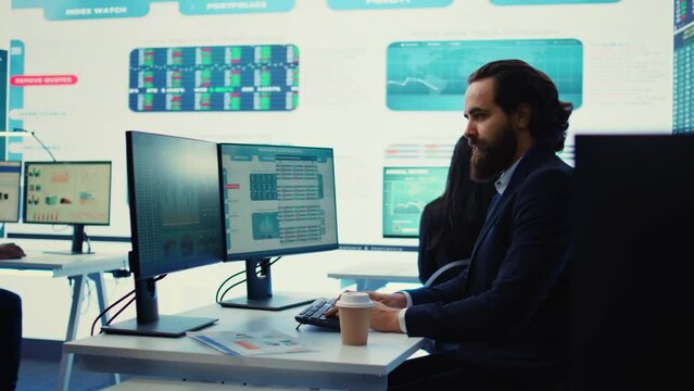 Corporate employee looking into project details and timetables in open coworking space, establishing budget and operations to accomplish goals in a competitive environment. Camera B.