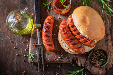 Spicy grilled sausage with bun made on bonfire grill.