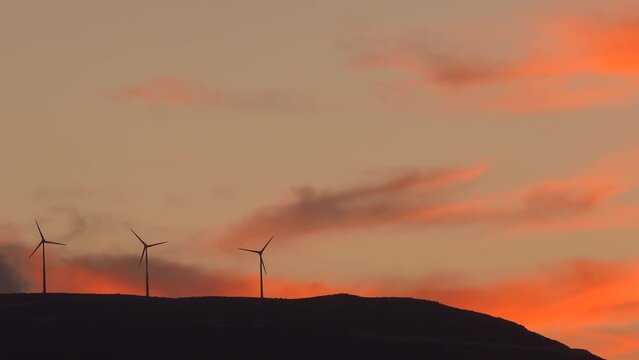 Clean energy power concept with wind turbine on top of a mountain during dram