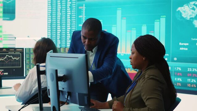Financial analyst works on resource allocation plans with his staff, analyzing reports and sales infographics to find revenue. Achieve objectives in a competitive business environment. Camera A.