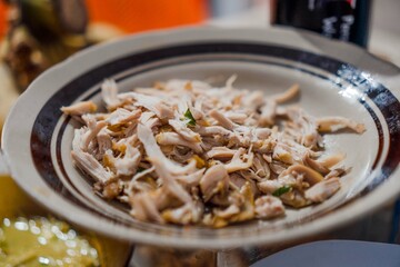 A plate of shredded chicken that will be used as a topping for soto