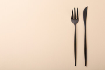 Stylish cutlery on beige table, top view. Space for text